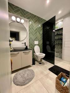 a bathroom with a sink and a toilet and a mirror at Luxury 2 Bedroom Top Central Apartment in Sofia +24 photos