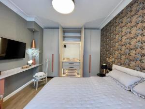 a bedroom with a large white bed and a tv at Luxury 2 Bedroom Top Central Apartment in Sofia