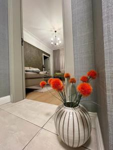 a vase filled with orange flowers sitting on a floor at Luxury 2 Bedroom Top Central Apartment in Sofia