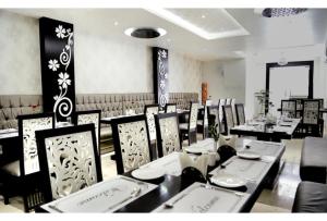 a dining room with tables and chairs in a restaurant at Hotel The Idea Inn in Agra