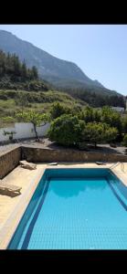 une grande piscine bleue avec une montagne en arrière-plan dans l'établissement Ultra deluxe Villa, à Kyrenia
