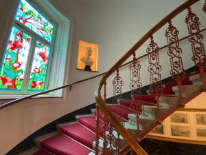 eine Wendeltreppe mit Buntglasfenster in der Unterkunft 7th HEAVEN Vienna Center Apartments in Wien