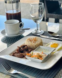 a white plate of food on a table with a drink at Amor Laut in Mabini
