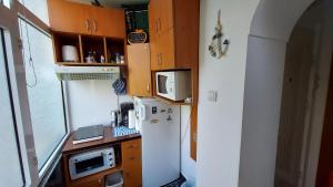 a small kitchen with a refrigerator and a microwave at Studio Olimp Black Sea in Olimp +23 photos