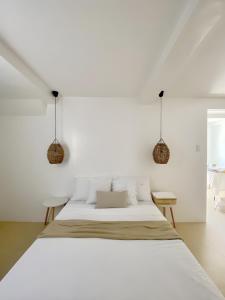 - une chambre blanche avec un lit et deux chaises dans l'établissement New Modern Suite Near Airport & Beach, à Sudtungan