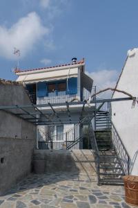 een huis met een balkon en een trap op een gebouw bij Samian Thalia Apartment in Pagóndas