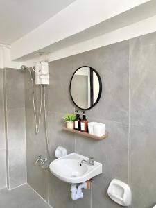 La salle de bains est pourvue d'un lavabo et d'un miroir. dans l'établissement New Modern Suite Near Airport & Beach, à Sudtungan