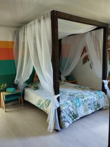 a bedroom with a bed with a canopy at Lodge le jardin créole in Bras-Panon
