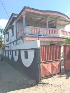 a house with a fence in front of it at TAMATAVE Chez Bien Aimée in Toamasina