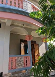 a house with a pink and blue trim at TAMATAVE Chez Bien Aimée in Toamasina