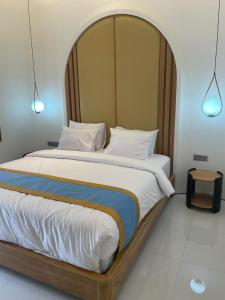 a bedroom with a large bed with a wooden headboard at Hotel Besar Purwokerto in Purwokerto