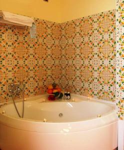 a bath tub in a bathroom with a tiled wall at Locanda Degli Agrumi in Conca dei Marini +37 photos
