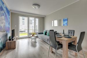 - un salon avec une table et un canapé dans l'établissement Apartament Letnica TriApart, à Gdańsk
