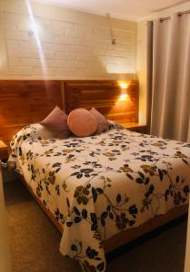 a bedroom with a bed with a floral comforter at Casas Lindas y acogedoras "PAQARI" in Vallenar