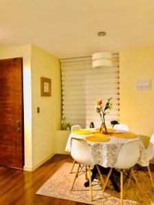 a dining room with a table and white chairs at Casas Lindas y acogedoras "PAQARI" in Vallenar