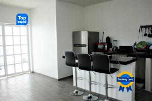 a kitchen with a refrigerator and a counter with chairs at Casa San blas Islitas 60 in San Blas