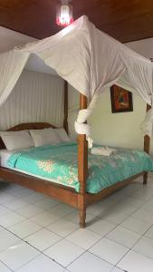 a bed with a canopy in a room at Barclona Guesthouses Lovina in Buleleng
