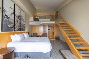 杭州的住宿－杭州西溪南庐君亭酒店，一间卧室设有一张床和一个楼梯