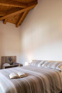 a bedroom with a large bed with an open book on it at Appartamenti Del Borgo in Borgosesia