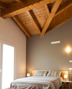 a bedroom with a large bed with wooden ceilings at Appartamenti Del Borgo in Borgosesia