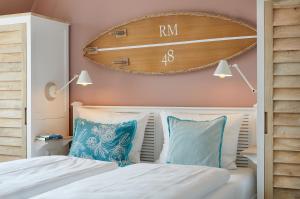 a bedroom with two beds and a large clock on the wall at Beach Apartments Büsum in Büsum