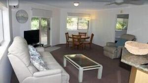 a living room with a white couch and a table at Norfolk Grove Apartment - Hosted by Burleigh Letting in Gold Coast