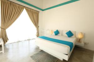 a bedroom with a bed and a large window at The Beach house by Kay Jay Hotels in Pasikuda