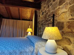1 dormitorio con cama y pared de piedra en El Rincón del Besaya en Villasuso de Cieza