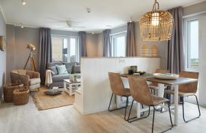 uma sala de jantar e sala de estar com mesa e cadeiras em Beach Apartments Büsum em Büsum