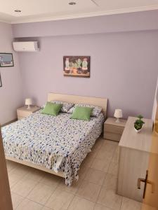 a bedroom with a bed with two green pillows at Panorama Beach House in Mascali