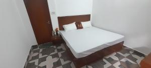 een klein wit bed in een kleine kamer bij Rani Palace in Khajurāho