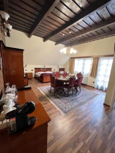 a living room with a table and chairs and a bed at Hotel Strk in Murska Sobota