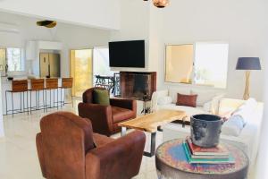 a living room with leather chairs and a table at Villa a la montagne Hammamet in Hammamet