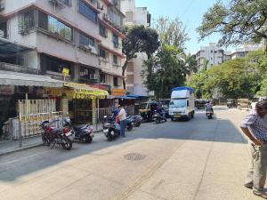a busy city street with motorcycles and a truck at OSI Apartments Carter's Road Bandra West in Mumbai
