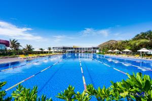 uma grande piscina com cadeiras e guarda-sóis em MIA Beach Villa - Oceanami Resort Long Hai Vung Tau em Long Hai