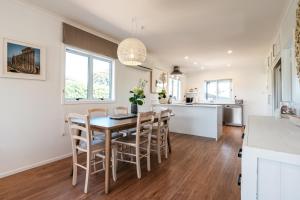 a kitchen and dining room with a table and chairs at Oneroa Coastal Classic - Coast & Country in Oneroa +33 photos