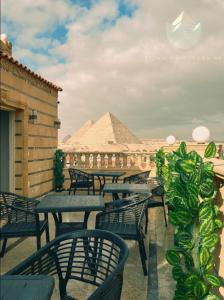 a row of tables and chairs with a pyramid in the background at Crowne Pyramids view inn in Cairo