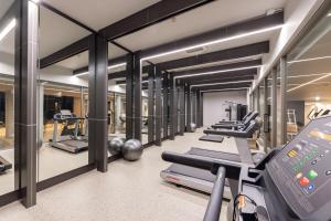 - une salle de sport avec des tapis de course et une rangée de machines dans l'établissement Travelodge Nimman, à Chiang Mai