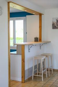 une cuisine avec un comptoir et deux tabourets dans l'établissement JOLIE MAISON - CALME - JARDIN - GAILLAC, à Gaillac