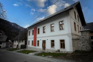 un edificio blanco con una raya roja. en Pr'Gavedarjo Eco Heritage B&B en Kranjska Gora