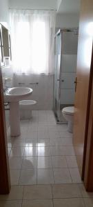 a bathroom with two sinks and a toilet and a window at Panorama Beach House in Mascali