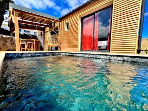 a swimming pool in front of a house at Anaélodge piscine privée chauffée 30 degrés in Le Tampon