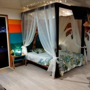 sypialnia z 2 łóżkami i baldachimem w obiekcie Lodge le jardin créole w mieście Bras-Panon