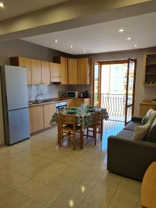 a kitchen and living room with a table and a refrigerator at Panorama Beach House in Mascali