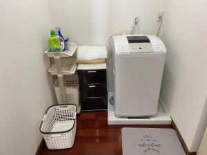 宮古島にある一棟貸しの宿 民宿せいじん家のランドリールーム(棚の上に洗濯機と乾燥機付)