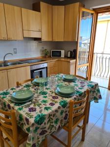 a kitchen with a table with plates and glasses on it at Panorama Beach House in Mascali