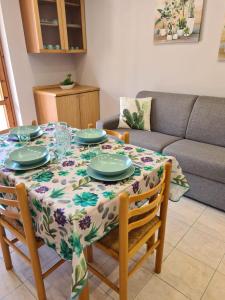 a dining room table with a table cloth on it with plates at Panorama Beach House in Mascali