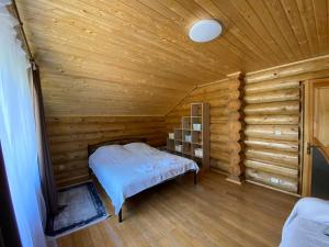 1 dormitorio con 1 cama en una habitación de madera en Приватна садиба GREEN HOUSE en Mizhhirʼʼya
