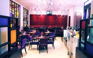 un restaurante con mesas y sillas de color púrpura y un bar en Garden Route Hotel en Mossel Bay