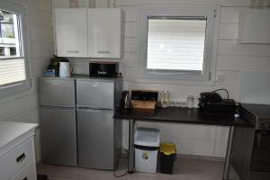 a small kitchen with a counter and a refrigerator at Domki nad jeziorem Kazub in Cieciorka